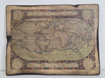 an old map of the world is displayed on a table