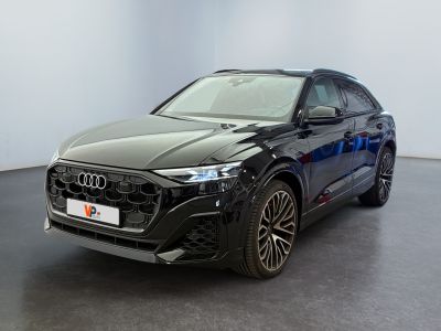 une Audi Q4 noire garée dans une pièce aux murs blancs