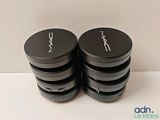 two black and white containers of mac cosmetics sitting on a table