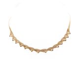 gros plan d'un collier en or sur fond blanc