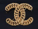 a close up of a gold chain link brooch
