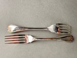 two forks that are sitting next to each other on a table