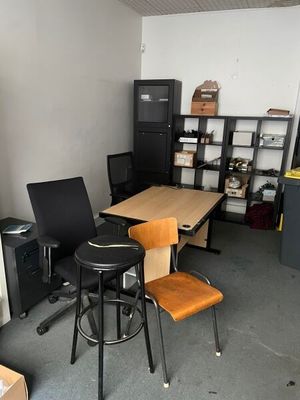 a room with a desk, chairs, and a television