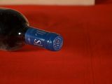 a bottle of wine sitting on a red table cloth
