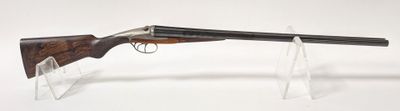 un pistolet avec un canon en bois et un étui transparent posé sur une surface blanche
