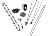 Divers colliers et pendentifs sont disposés sur une surface blanche