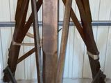 a wooden tripod sitting in the middle of a room