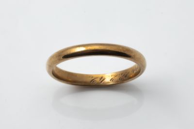 a close up of a gold ring on a white surface
