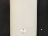 un grand chauffe-eau blanc posé directement sur un sol en béton
