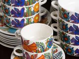 many cups and saucers that are sitting on a table