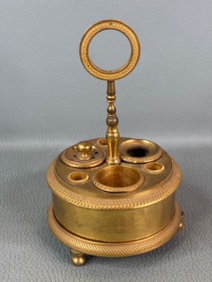 an image of a gold colored clock with a key on top of it