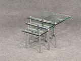 trois tables en verre posées sur un sol recouvert de moquette