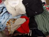 a pile of clothes that is sitting on a bed