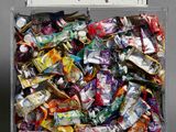 une boîte transparente remplie d'un assortiment de bonbons et de barres chocolatées