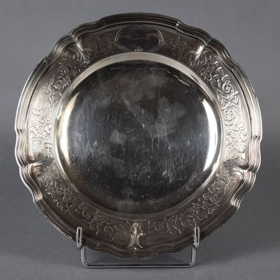 un plateau d'argent antique sur un support sur fond gris