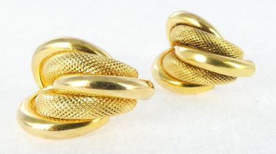 a pair of gold toned earrings with a knot design