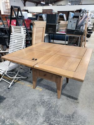 a table and chairs in a warehouse with a lot of furniture
