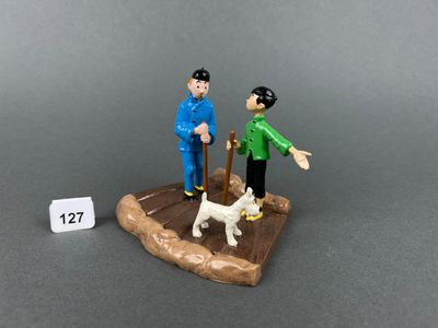two figurines of a man and a dog on a table