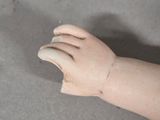 a hand that is sitting on the floor next to a doll ' s hand