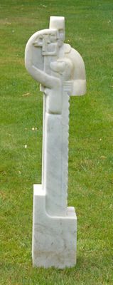 une statue représentant un homme tenant une épée dans un champ herbeux