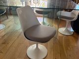 a glass table with chairs and a chair in it