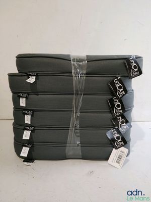 quatre bagages emballés dans du plastique, posés sur une surface blanche