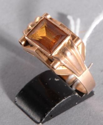 une bague en or sertie d'une pierre orange