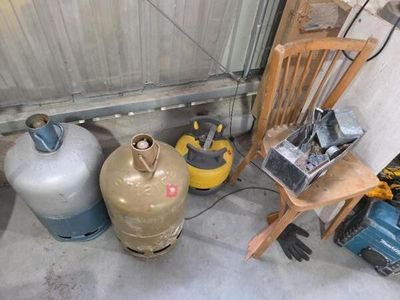 de nombreuses bouteilles de gaz et une chaise dans un garage