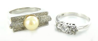 deux bagues ornées de perles et de diamants sur un fond blanc