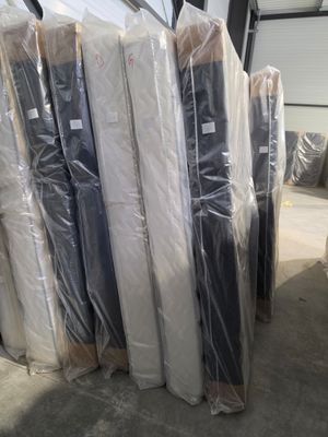 a lot of mattresses wrapped in plastic in a warehouse