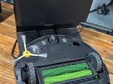 a robot that is sitting on the floor next to a laptop
