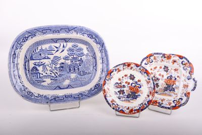 trois assiettes bleues et blanches et un plat de service posés sur un plan de travail blanc