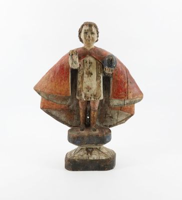 an old wooden statue of a man with a cape on a white background