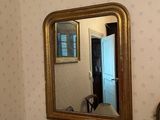 un miroir accroché au mur au-dessus d'une lampe dans une pièce