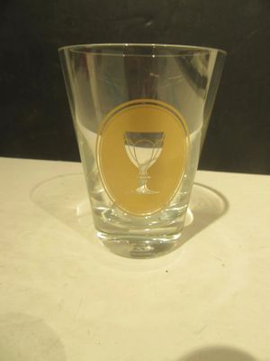 a shot glass sitting on a table with a shadow on the table
