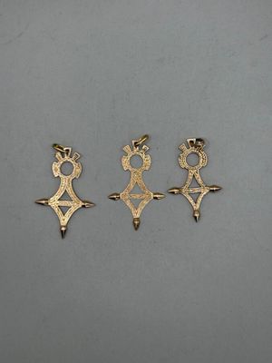 three gold earrings with a crown and a cross on them
