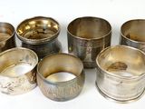 Plusieurs coupes en argent sont disposées en cercle sur une surface blanche