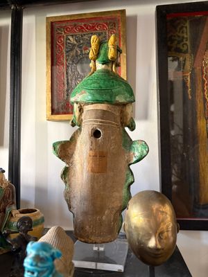 many vases that are sitting on a shelf in a room