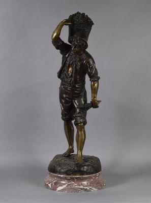 a bronze statue of a man with a basket on his head and a hat on his head