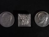 three different types of silver coins on a black surface