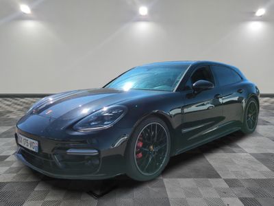 une Porsche Panamera noire garée sur un sol en carrelage à damier