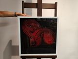 a person standing next to a painting on a easel