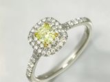 une bague de fiançailles sertie d'un diamant jaune entouré de diamants blancs