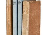 trois livres sont empilés sur une surface blanche