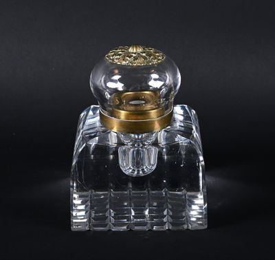 flacon de parfum en verre transparent avec un bouchon doré, sur fond noir
