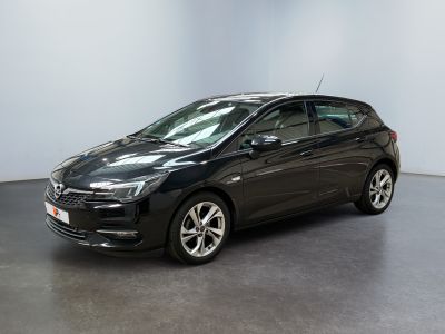 L'Opel noire est garée dans une pièce aux murs blancs.