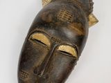 une image d'un masque en bois accroché au mur