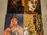 quatre tableaux représentant une femme et un homme sont posés par terre