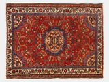 un tapis rouge avec un motif de médaillon sur fond blanc