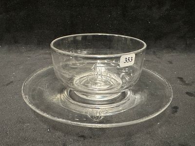 une tasse en verre et sa soucoupe posées sur une soucoupe